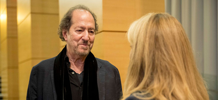 MSK patient and jazz musician Michael Wolff, dressed in black and standing, smiles in conversation.