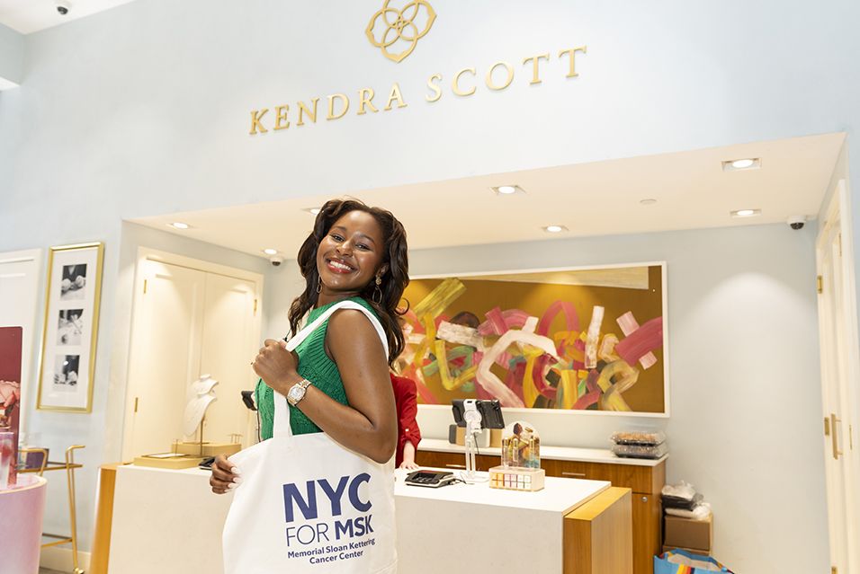 A person holding an NYC for MSK tote bag inside the Kendra Scott store.  