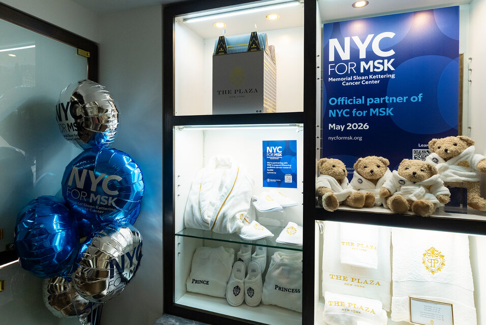 A display inside the Plaza Hotel gift shop showing robes, teddy bears, and slippers surrounded by NYC for MSK balloons and signage.